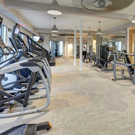 a spacious gym with treadmills, elliptical machines, and other exercise equipment.