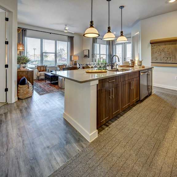 a kitchen with a large island and pendant lights.