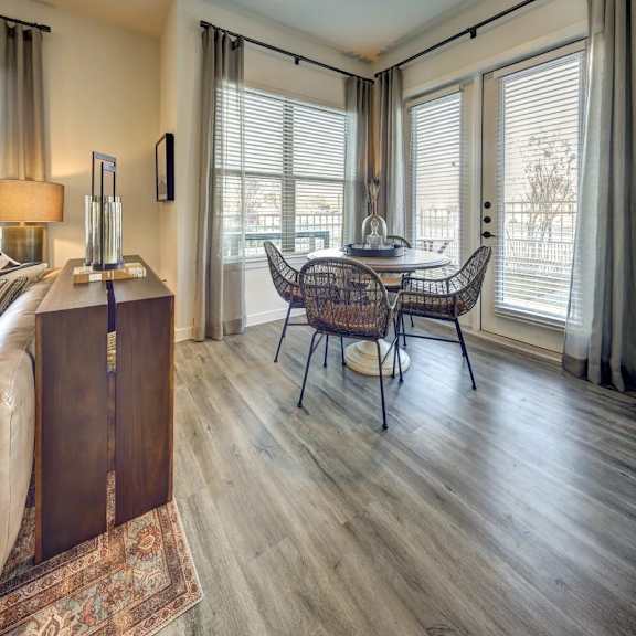a room with a wooden floor and a table with chairs.