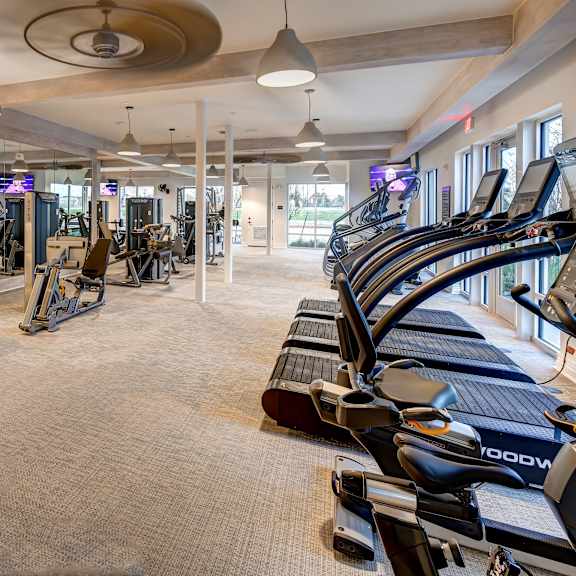 a gym with treadmills, weights, and exercise equipment.