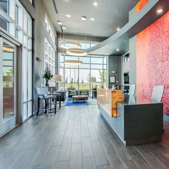 a reception area with a large red wall and a wooden reception desk.