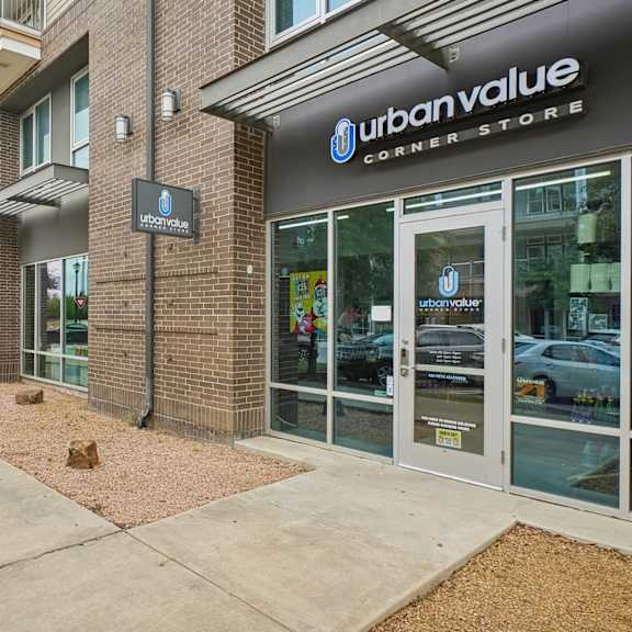 a storefront of urban value corner store with a sidewalk in front.