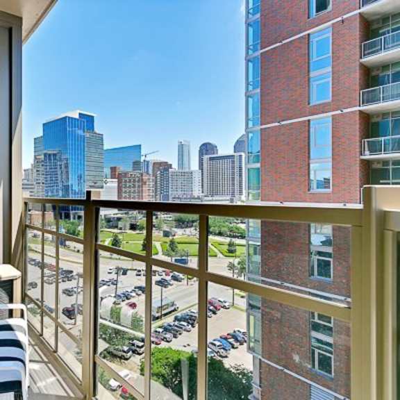 a cozy balcony here at victory place with a couch and a view of a city skyline.