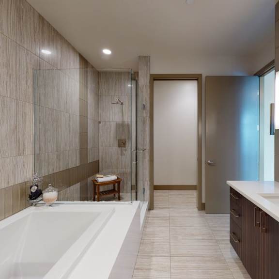 a modern bathroom with a large tub and a double sink vanity.