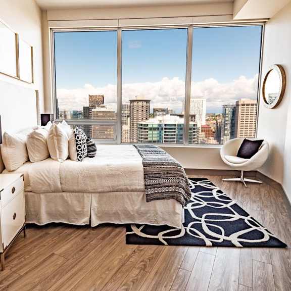 a bedroom with a large bed and a view of the city.