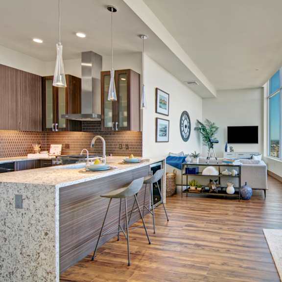 a modern kitchen with a large island and a view of the city.