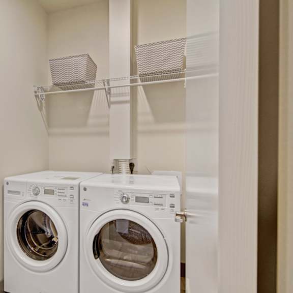 two white front loading washing machines in a small laundry room.