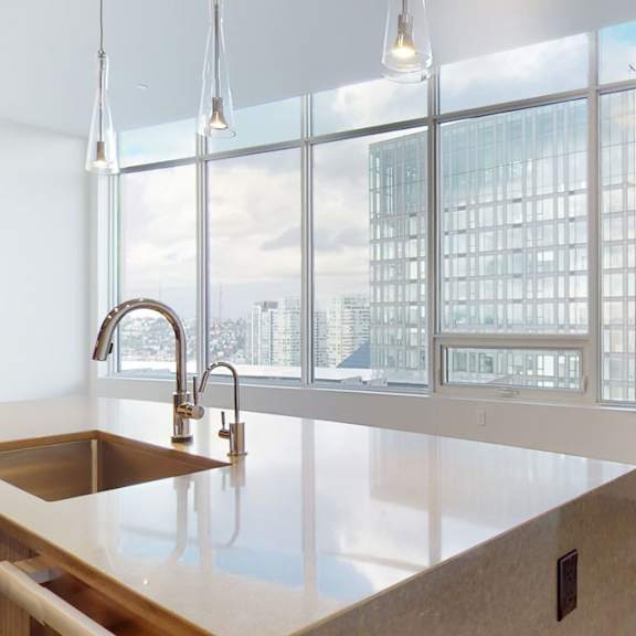 a kitchen with a large window overlooking a cityscape.