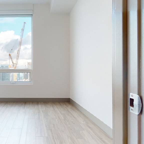 a room with a view of a construction site through the window.