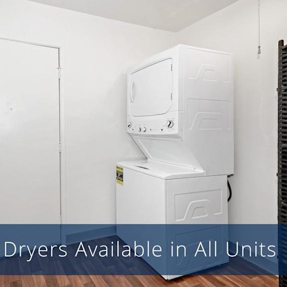 a small laundry room here at the glen apartments with a white stacked washer and dryer on the right, a closed white door on the left, and wood-patterned flooring. bright and functional.