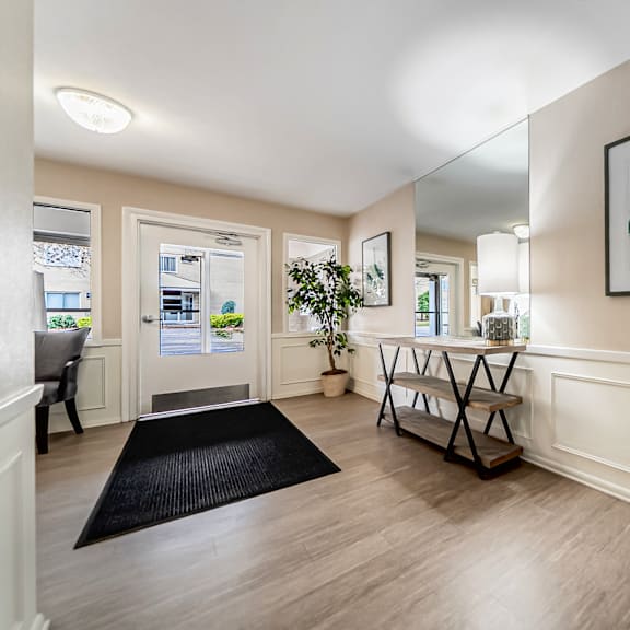 a hallway with a black rug and a framed picture on the wall.