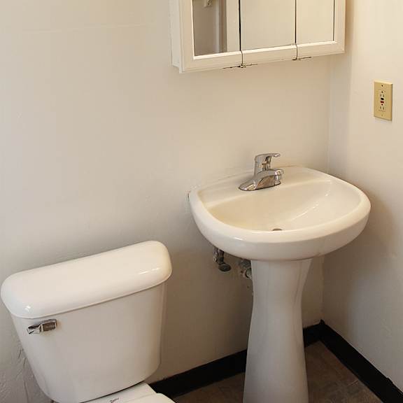 a white toilet and sink in a bathroom.