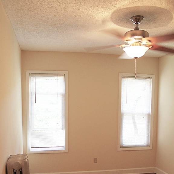a room with a wood floor and a ceiling fan.