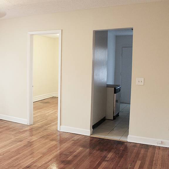 a room with a wood floor and a ceiling fan.