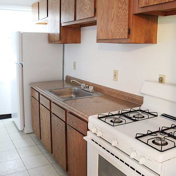a kitchen with a white stove and wooden cabinets.