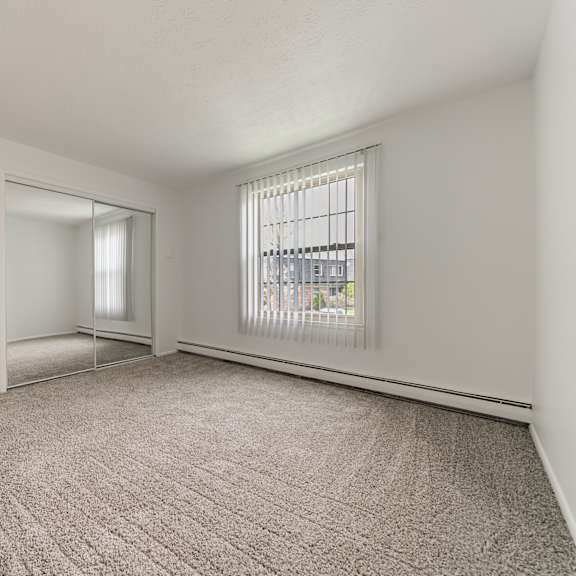 carpeted bedroom with sliding mirrored closet