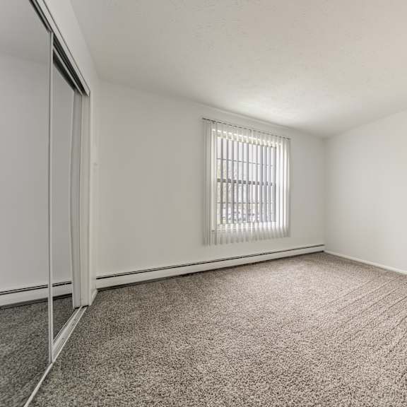 carpeted bedroom with sliding mirrored closet