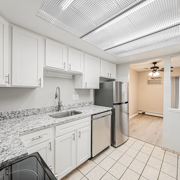 a kitchen with white cabinets and granite countertops.
