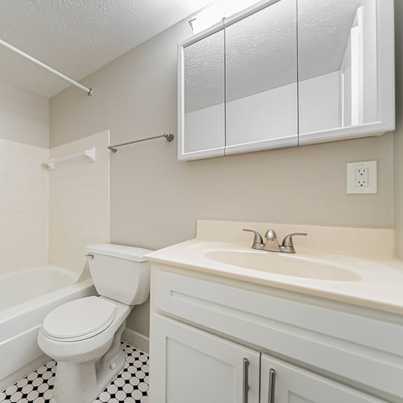 a white bathroom with a toilet, sink, and bathtub.