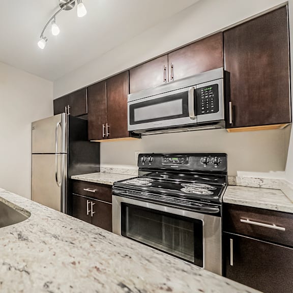 a kitchen with a sink, stove, and refrigerator.