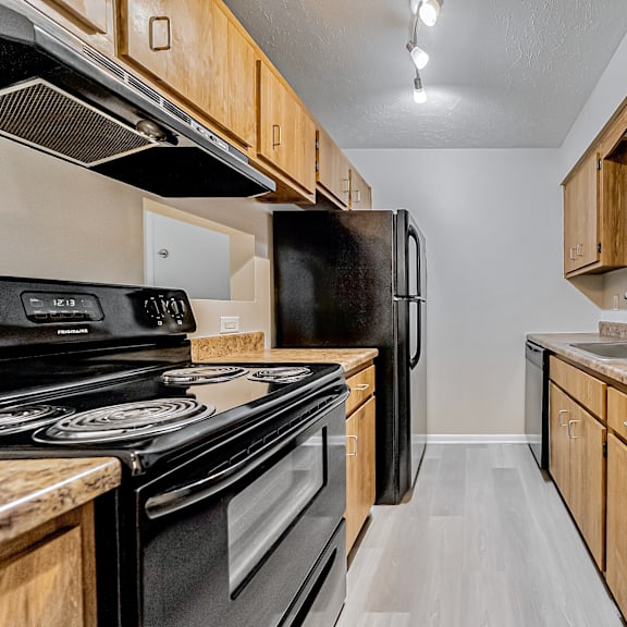 galley kitchen with light wood cabinetry.
