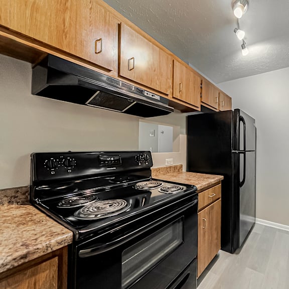 a kitchen with a black stove and refrigerator.