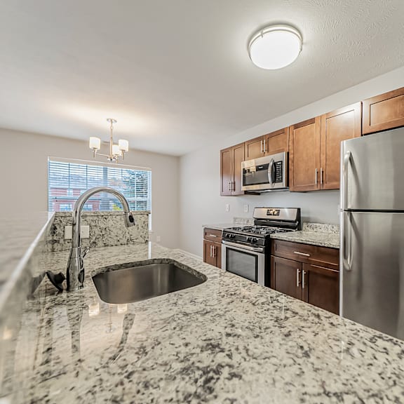 townhome updated kitchen with granite counters and stainless steel appliances.