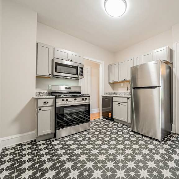 a kitchen with a black and white tiled floor.