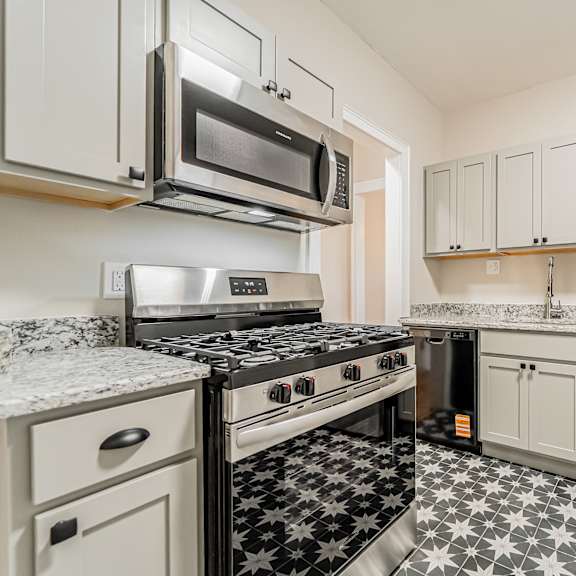 updated kitchen with stainless steel appliances and a black and white floor. at integrity gold coast apartments, apartments, cleveland, oh