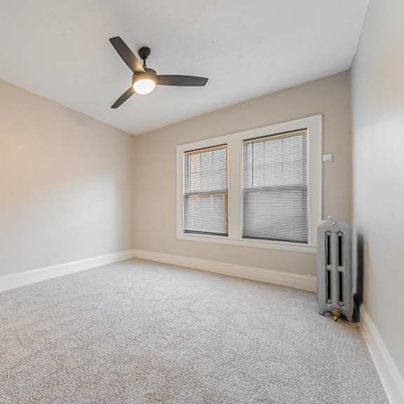 carpeted bedroom with modern ceiling fan.