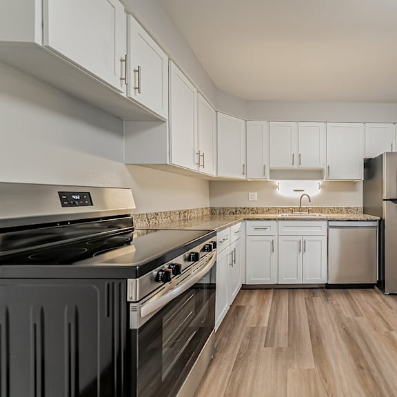 a kitchen with a black stove top oven and white cabinets.