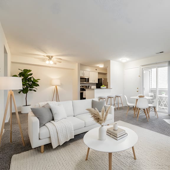 a living room with a white couch, a white coffee table, and a fireplace at hunt club apartments, copley, ohio