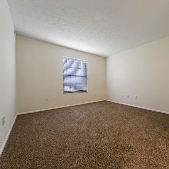 a room with a carpeted floor and a window with blinds at hunt club apartments, apartments, copley, oh