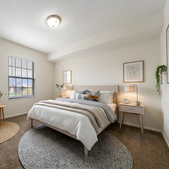 a bedroom with a bed, chair, and two lamps at hunt club apartments, copley, 44321