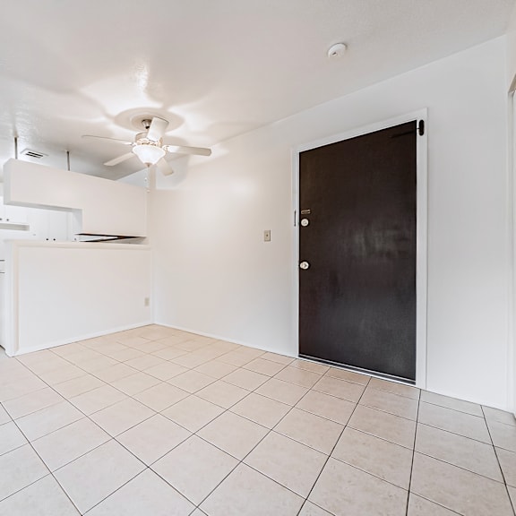 a room with a black door and a ceiling fan.