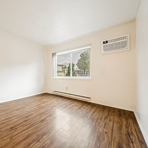 a room with a window and a wooden floor.