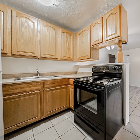 a kitchen with wooden cabinets and a black oven.