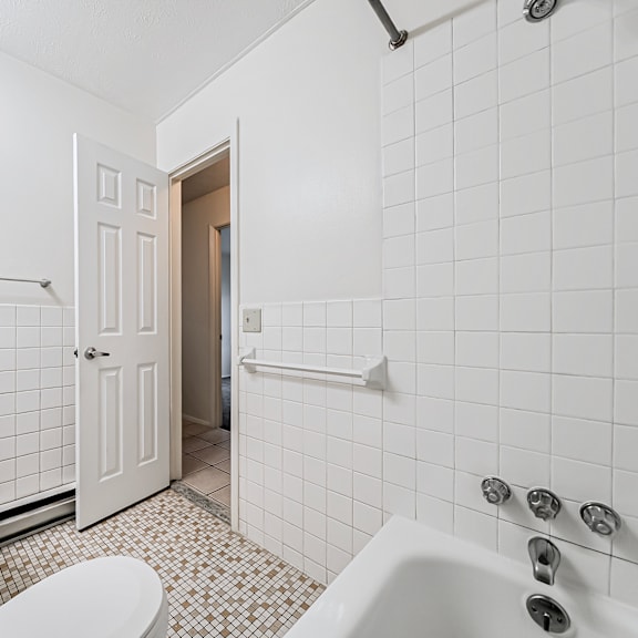 a white bathroom with a toilet, sink, and bathtub.