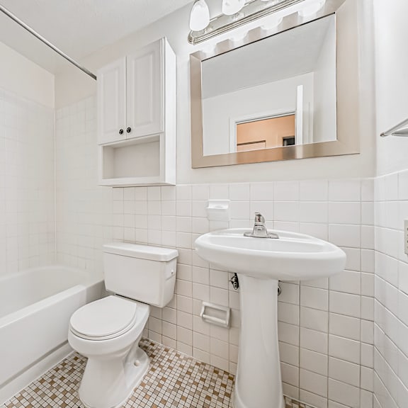 a white bathroom with a toilet, sink, and bathtub.