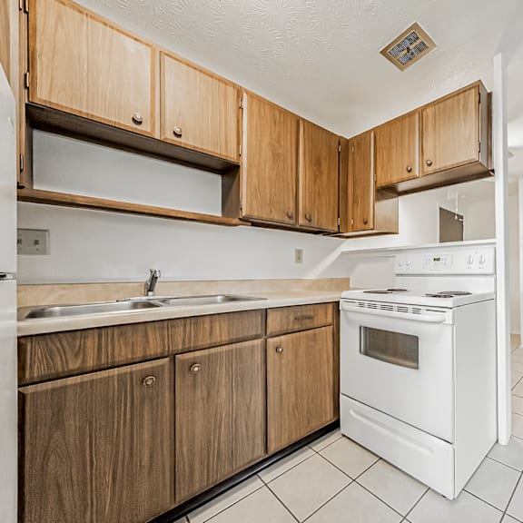 a kitchen with wooden cabinets and white appliances.
