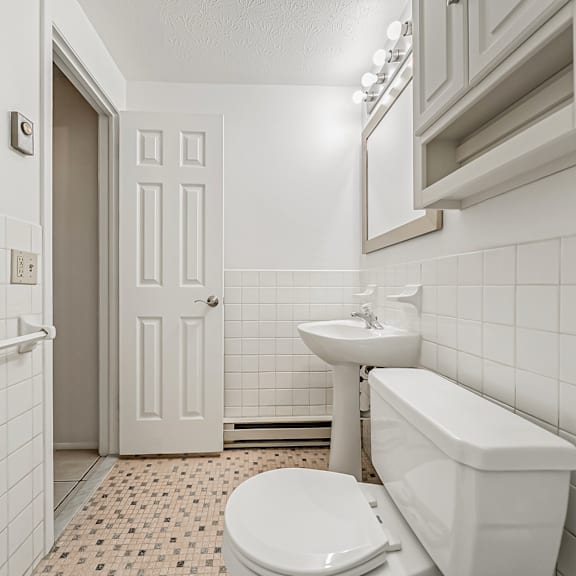 a white bathroom with a toilet, sink, and bathtub.