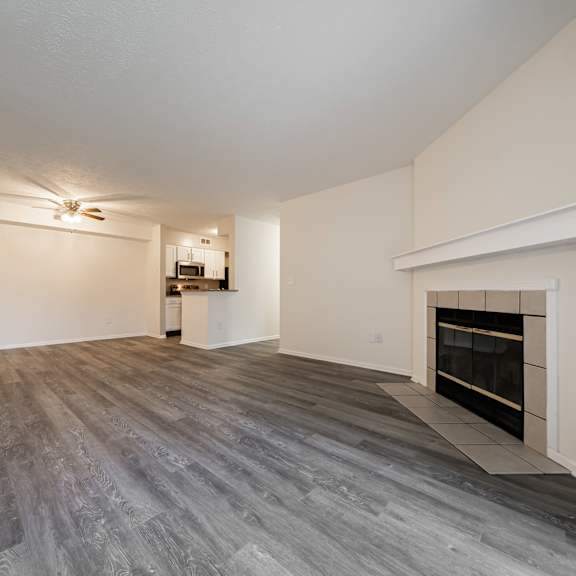 a spacious living room with a fireplace and a ceiling fan at hunt club apartments, copley, oh, 44321