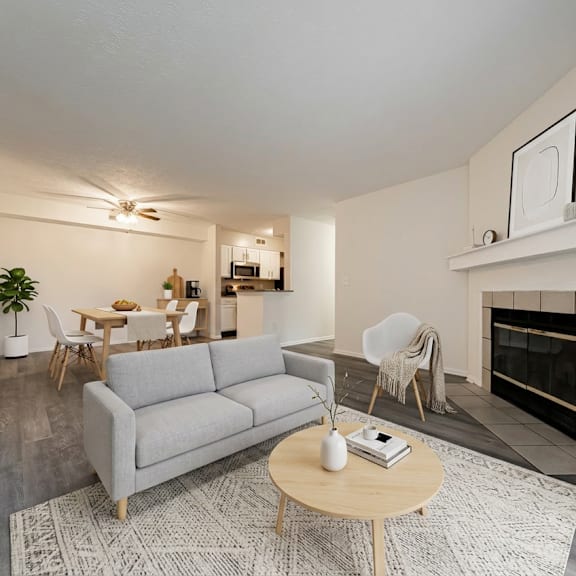 a living room with a grey couch, a coffee table, and a fireplace at hunt club apartments, ohio