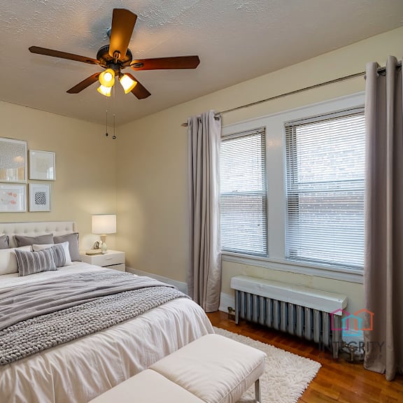 a bedroom with a bed, nightstands, and a ceiling fan.