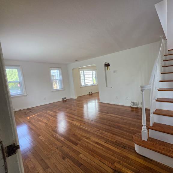 a room with wooden floors and a staircase.