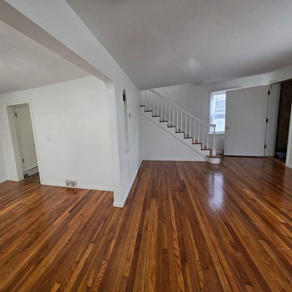 a room with wooden floors and white walls.