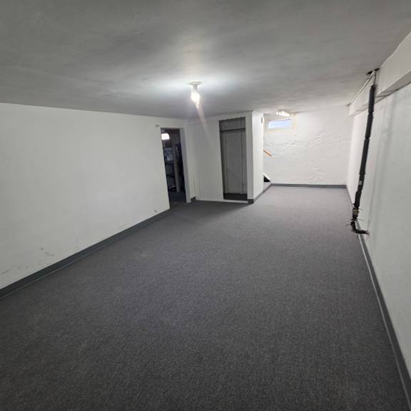 a long, narrow hallway with a carpeted floor and white walls.