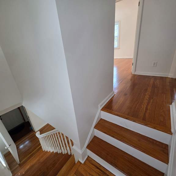 a staircase with white railings and wooden steps.