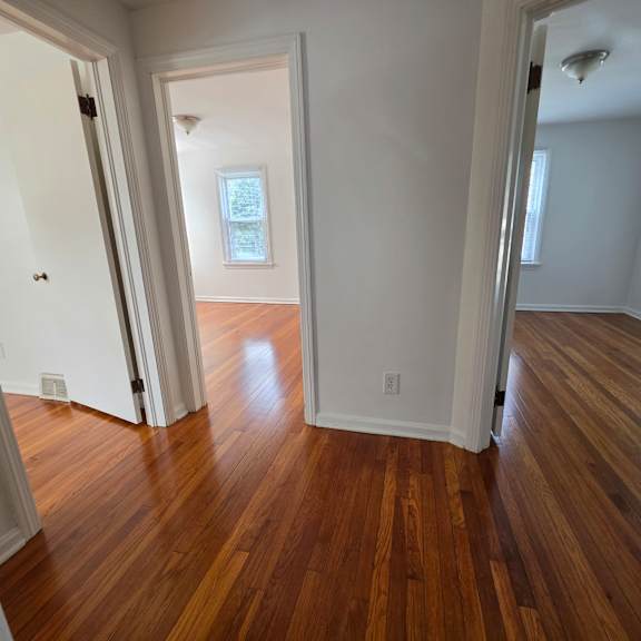 a room with wooden floors and white walls.