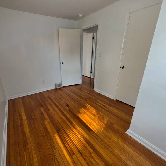 a room with wooden floors and white walls.